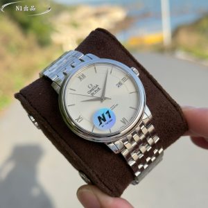 N1 Factory's latest masterpiece: the De Ville Classic Collection watch. Crafted by N1 to honor timeless classics, this 39.5mm Swiss Chronometer watch embodies supreme quality. Its elegant, slim profile paired with a minimalist yet sophisticated design showcases N1's meticulous attention to detail, perfectly capturing the original's classic charm for business elegance. 1: Dimensions: 39.5mm x 10mm.Dial markers and hands fully replicate the original manufacturing process: precision grinding and polishing followed by rhodium plating ensures enduring brilliance and remarkable presence. 2: The Omega resistance logo on the dial features perfectly executed curvature and naturally chamfered edges. Though seemingly delicate and insignificant, its intricate craftsmanship conceals profound artistry.3: This watch features an authentic-style steel bracelet molded in a 1:1 replica of the original. The outer logo etching depth is consistent, with the Omega symbol possessing a three-dimensional texture and quality. The rivets on the clasp, like the original, are CNC-machined as a single unit with the clasp itself, eliminating the common issues of rivets falling off or breaking.4: N1 Factory's latest flagship model features an independently developed 2500 integrated movement, outperforming standard movements in other market versions and achieving truly zero returns. For Omega De Ville replicas, trust N1 Factory.